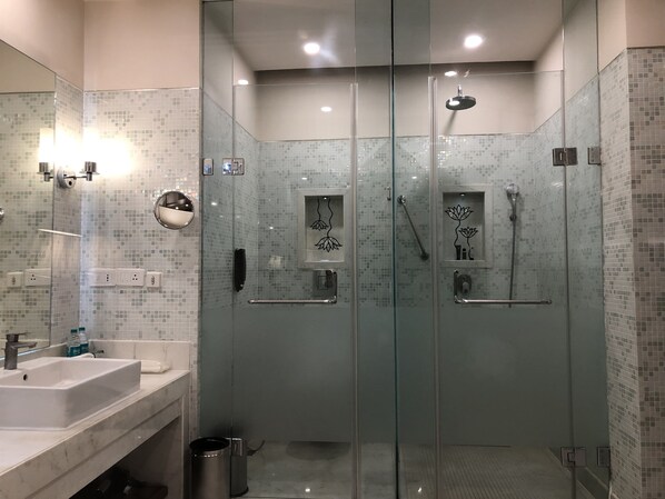 A modern bathroom with a glass-enclosed shower, a sink, and a mirror.