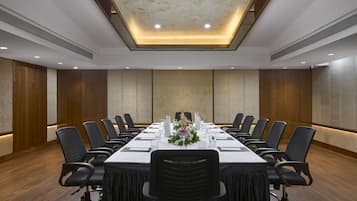 A conference room with a long table, chairs, and a floral centerpiece.