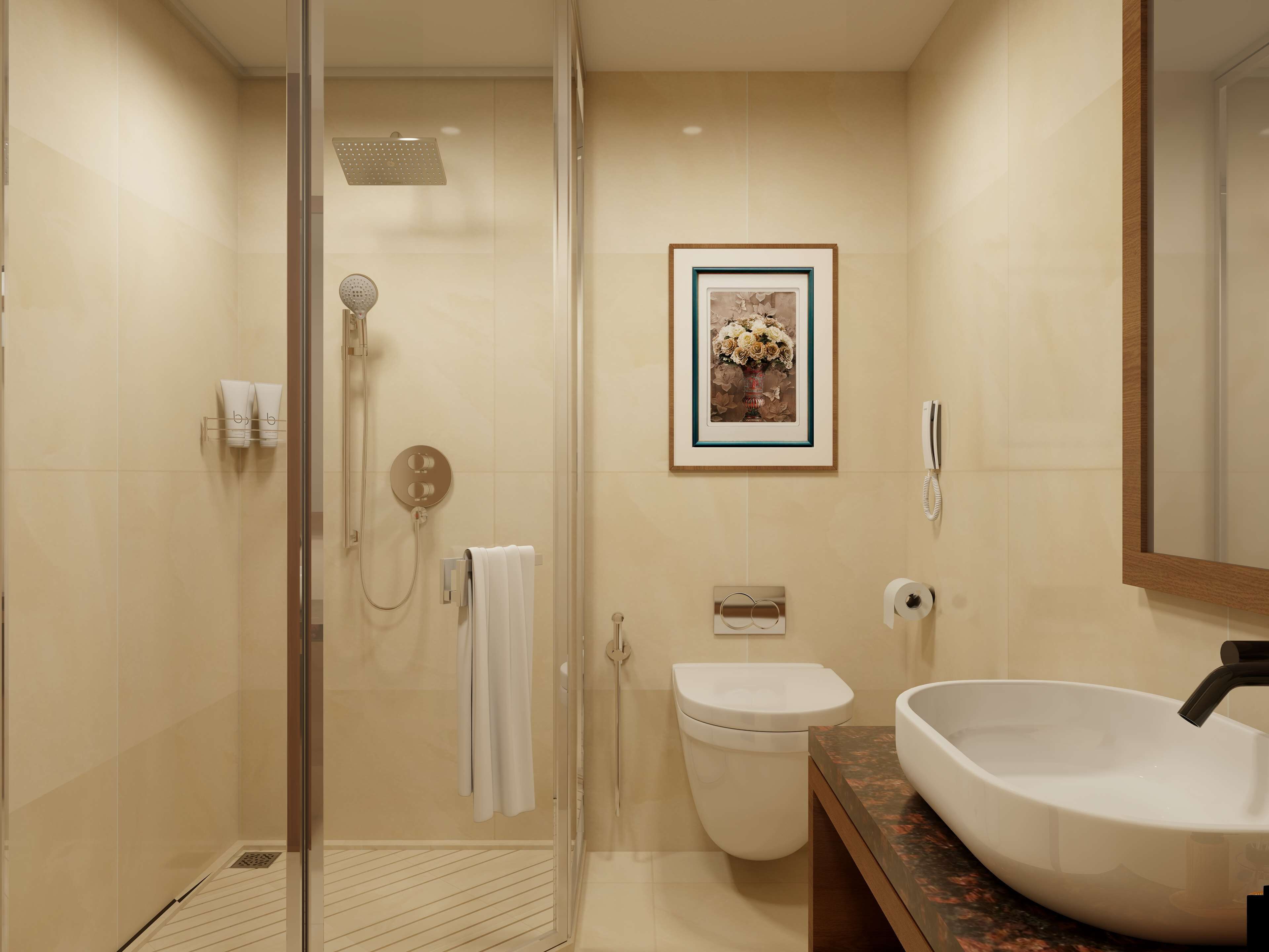 A modern bathroom with a glass-enclosed shower, a white toilet, a framed picture on the wall, and a large sink with a marble countertop.