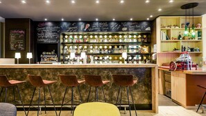 A bar area with a counter, stools, and shelves stocked with bottles. - Mercure Hotel Hannover Mitte (Hannover)