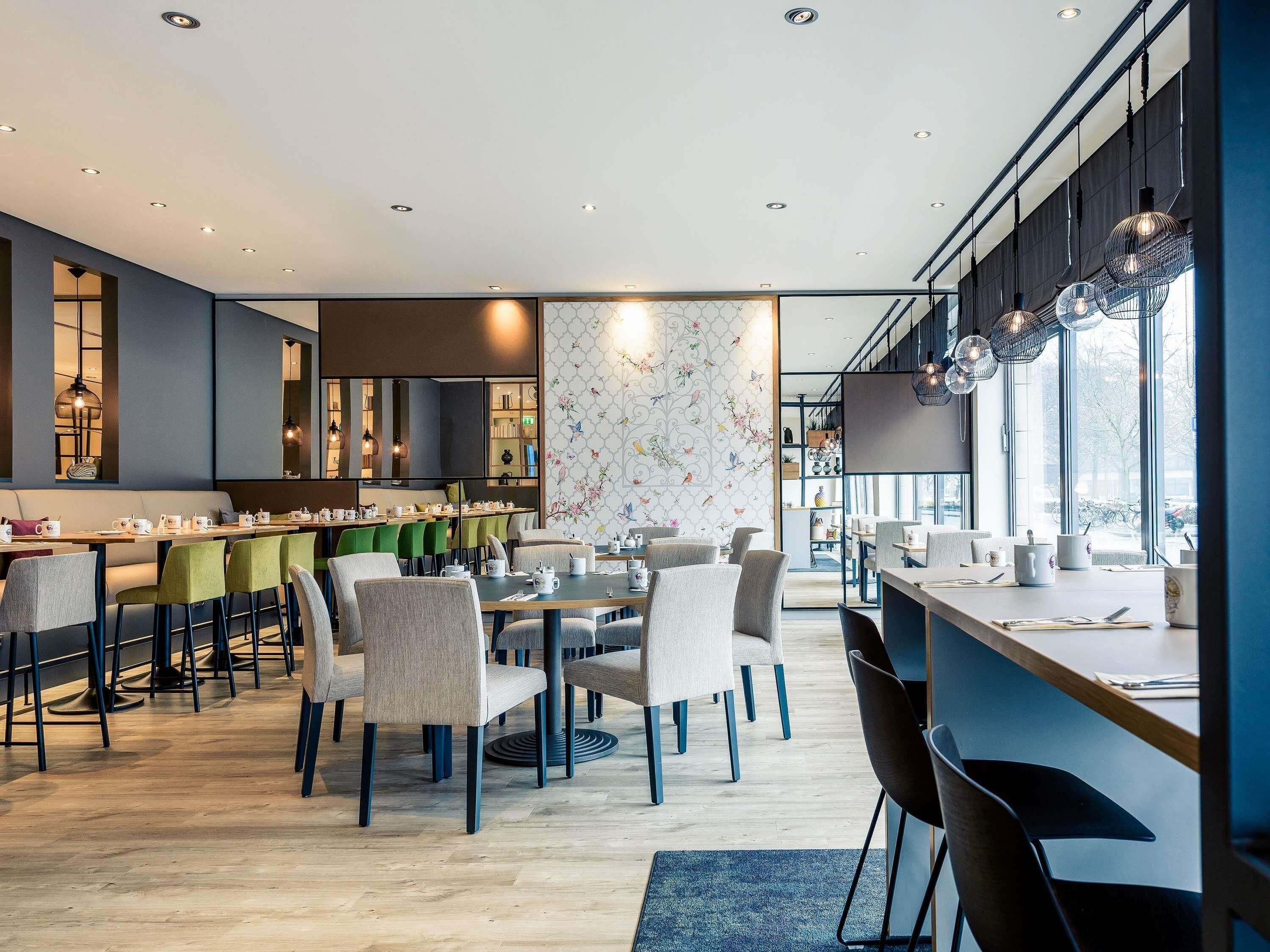 Un comedor moderno con una mesa larga, sillas y una barra.