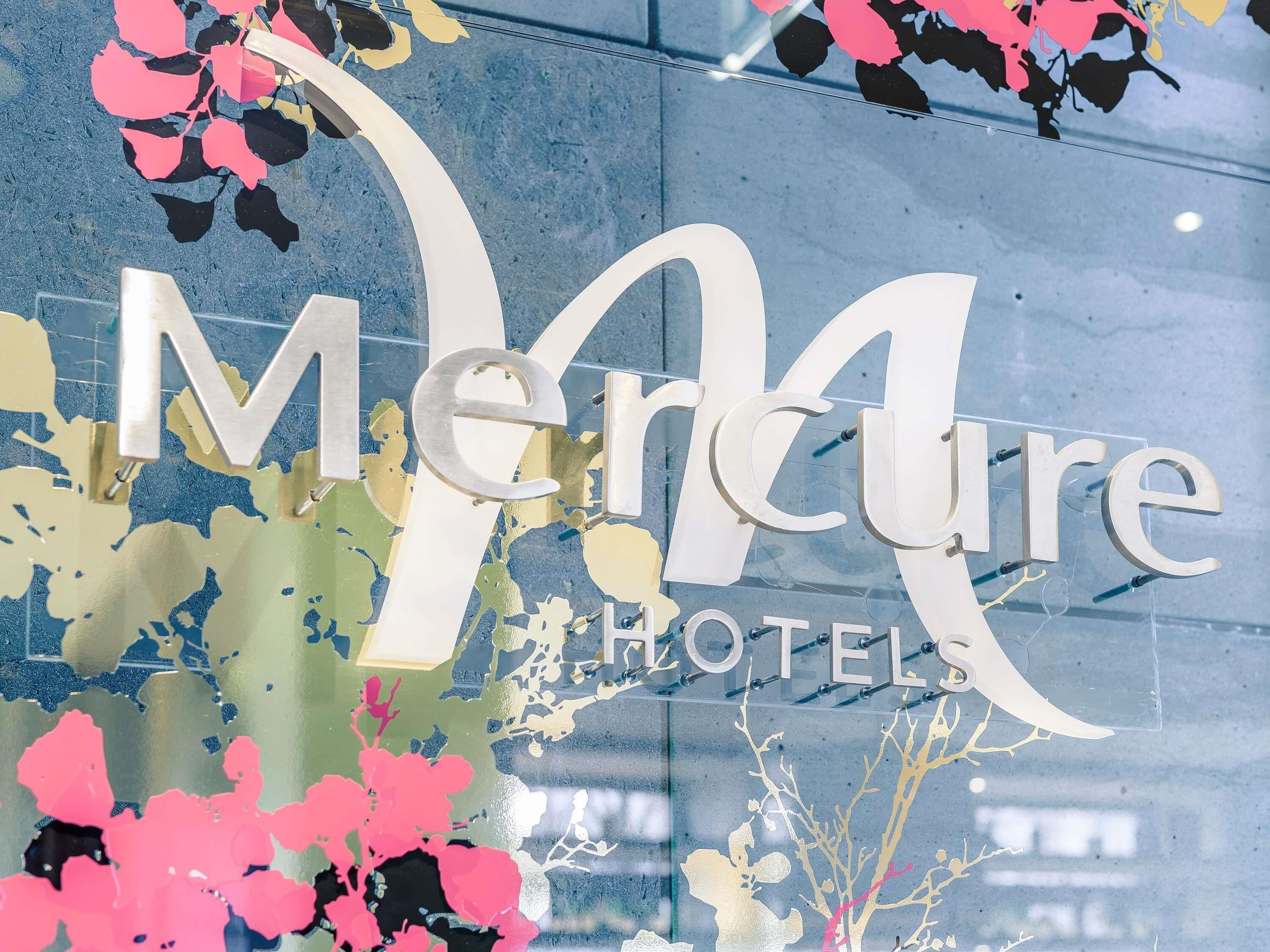 A hotel sign with the name 'Merure Hotels' in large letters.