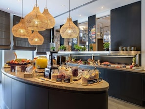 A buffet counter with various food items and a coffee machine. - Mercure Hotel Hannover Mitte (Hannover)