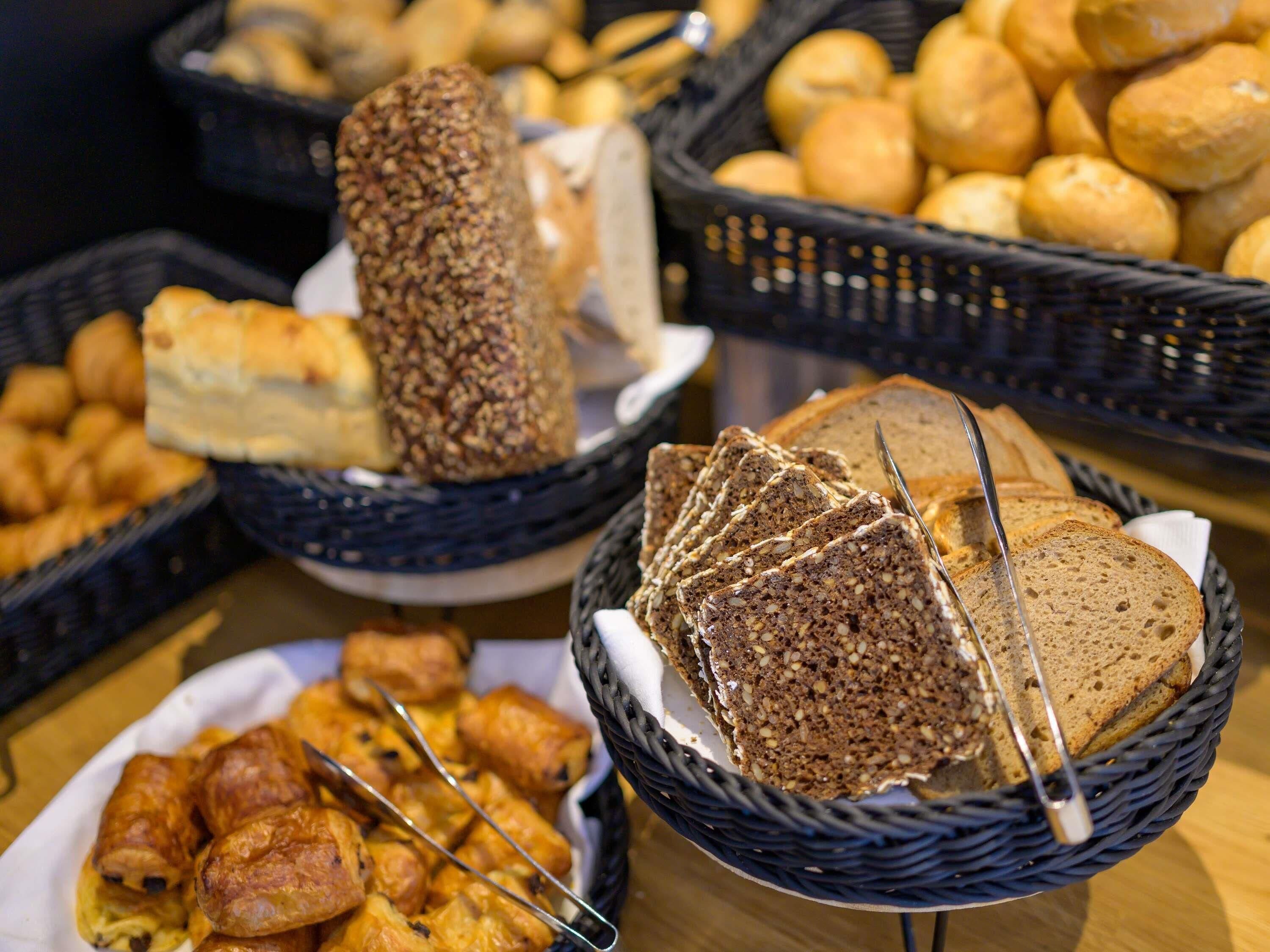 A variety of breads and pastries in baskets.
