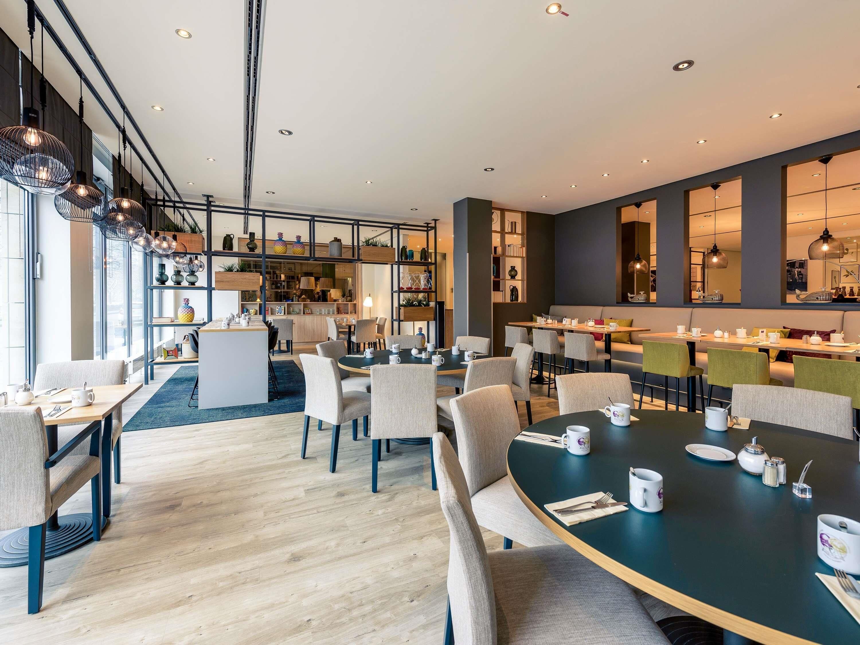 Un comedor moderno con mesas redondas, sillas y diversos objetos decorativos.