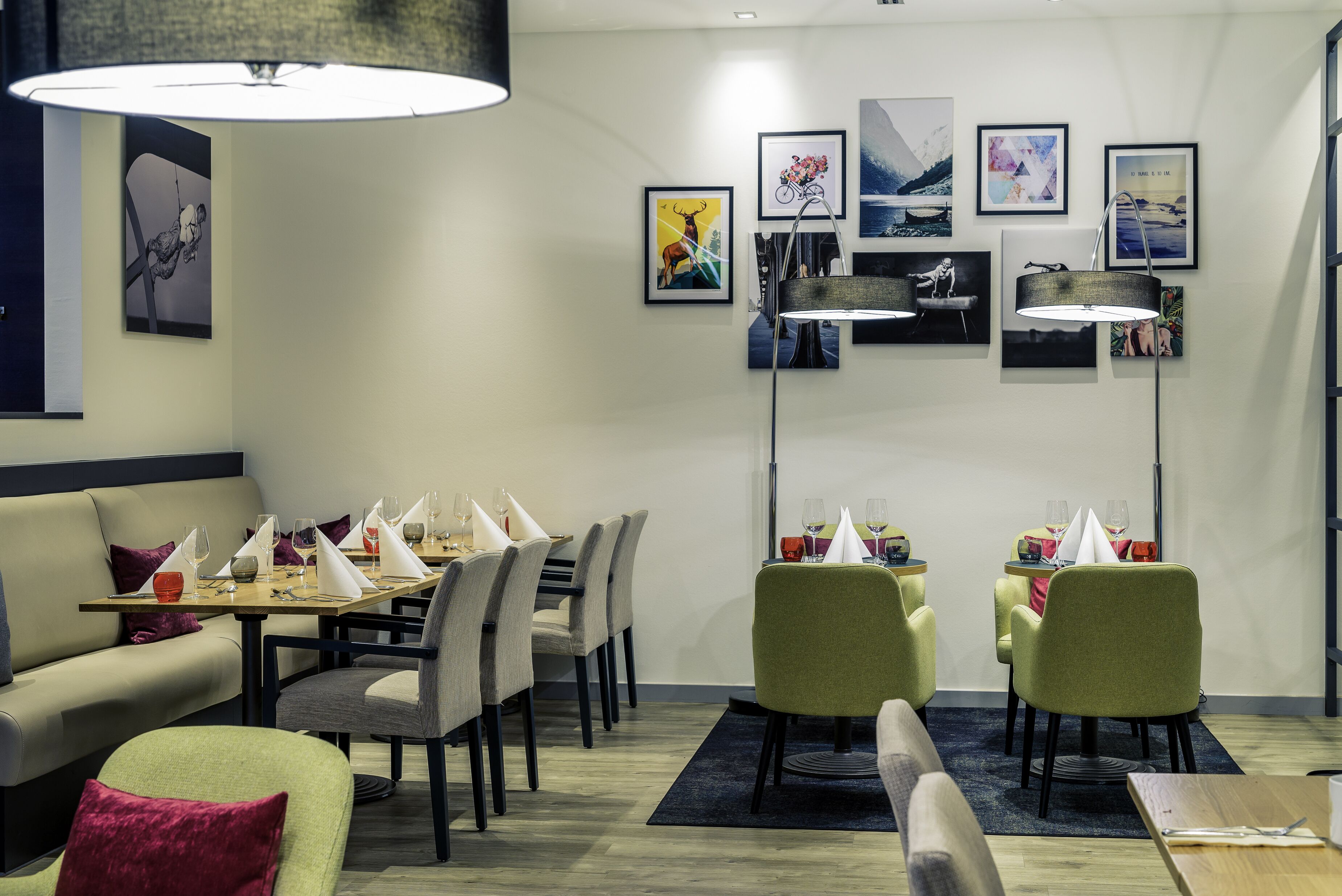 Een moderne eetruimte met een bank, eettafel, stoelen en kunstwerken aan de wanden.