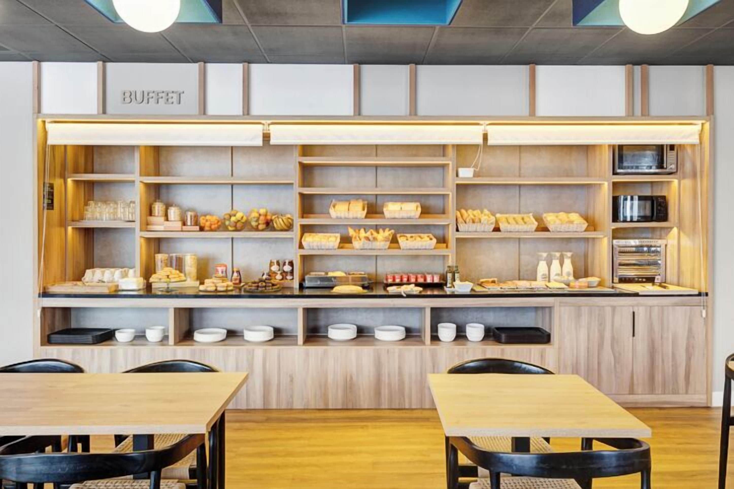 Buffet-alue, jossa on puuhyllyjä ja -pöytiä, ja kyltti, jossa lukee ”BUFFET”.