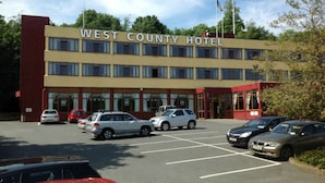 Ein Hotel in West County mit Parkplatz und mehreren parkenden Autos davor.