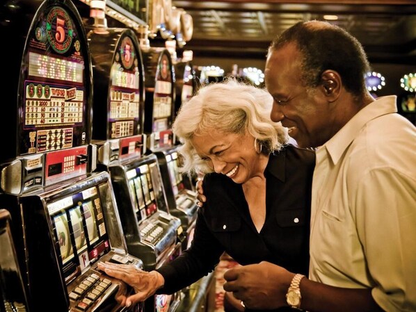 A casino environment with slot machines and a man and woman interacting with one of the machines. - Boomtown Casino & Hotel (Bossier City)