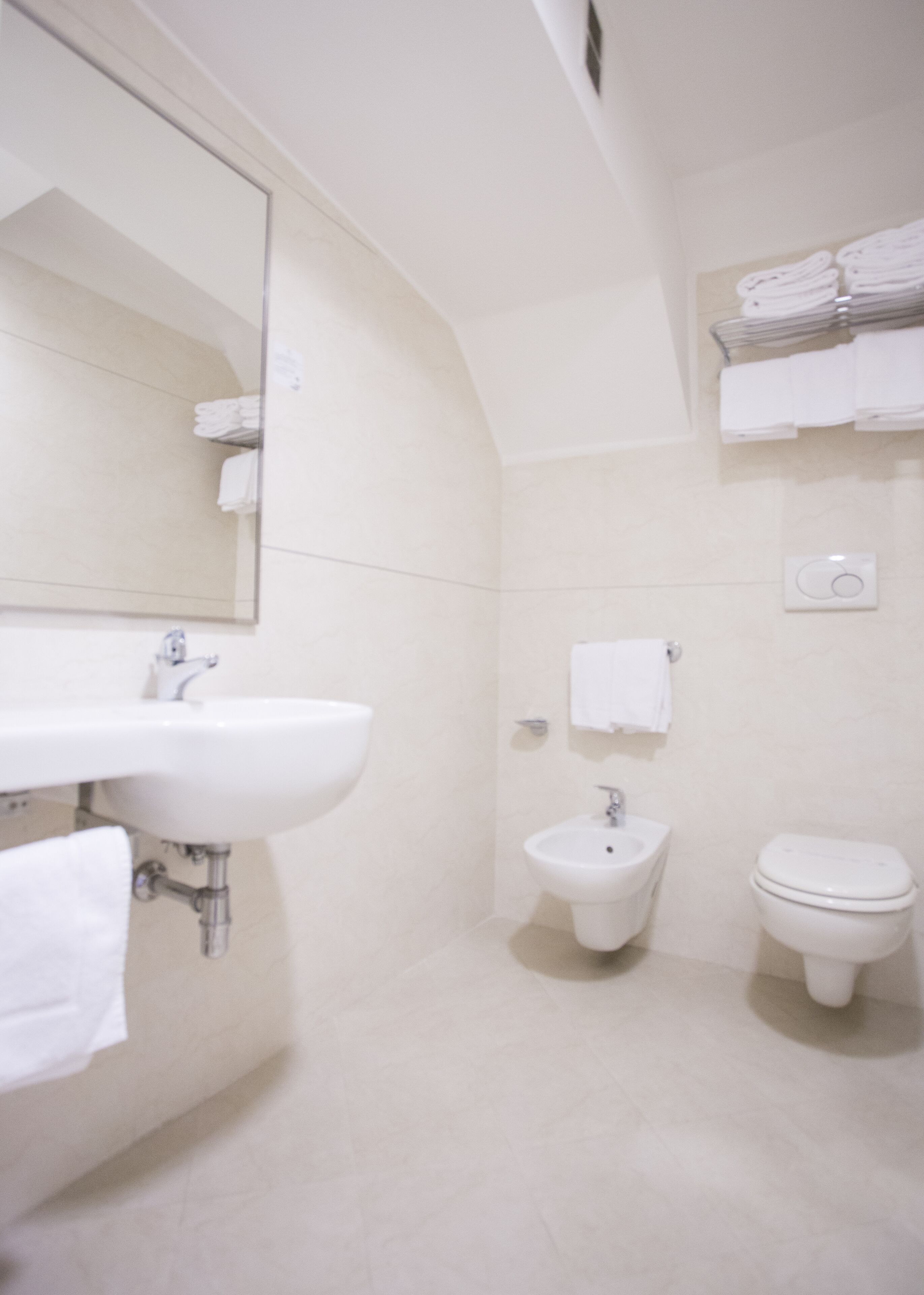A bathroom with a sink, bidet, and toilet.