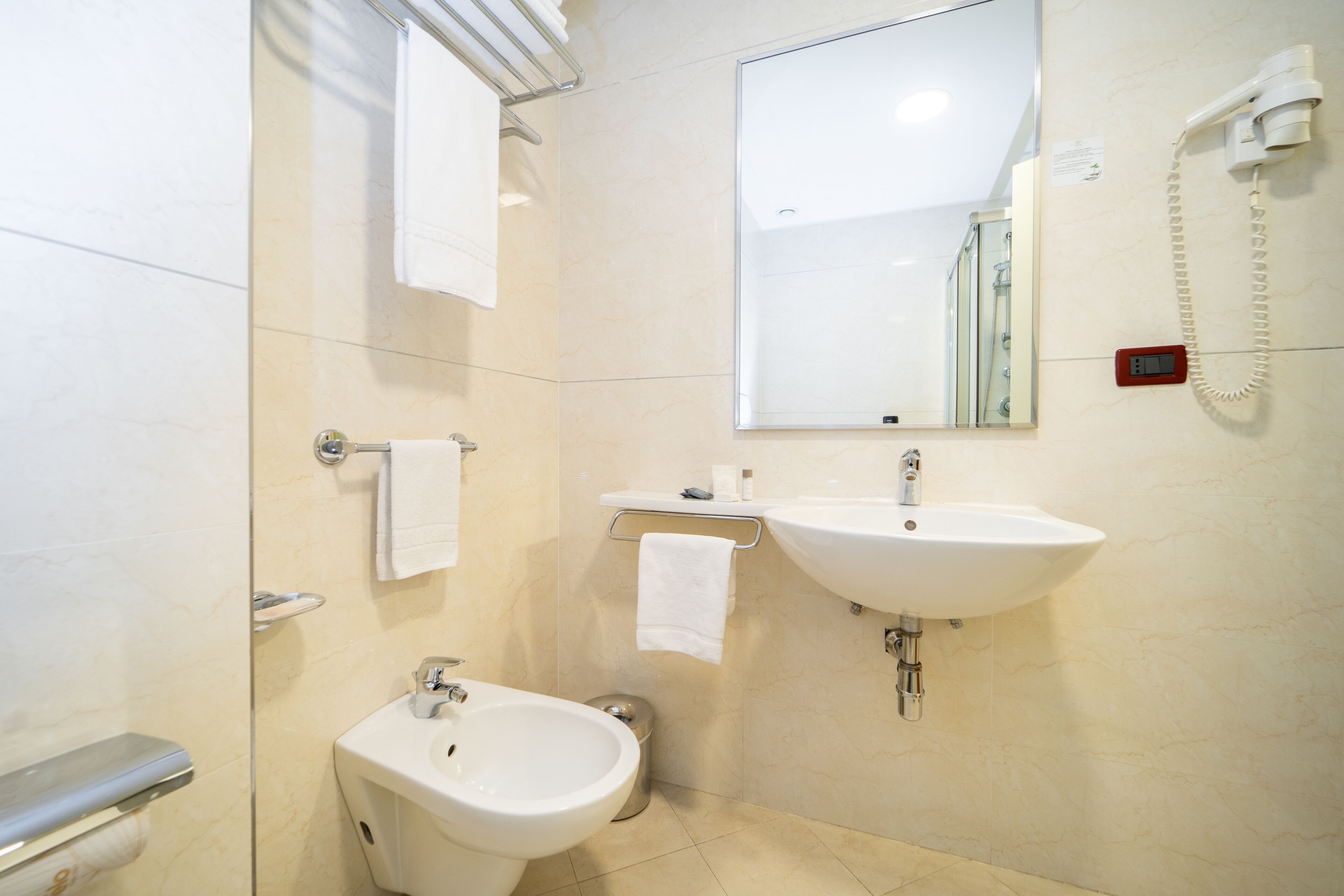 Un baño moderno con dos lavamanos, un bidé, un inodoro y una ducha.