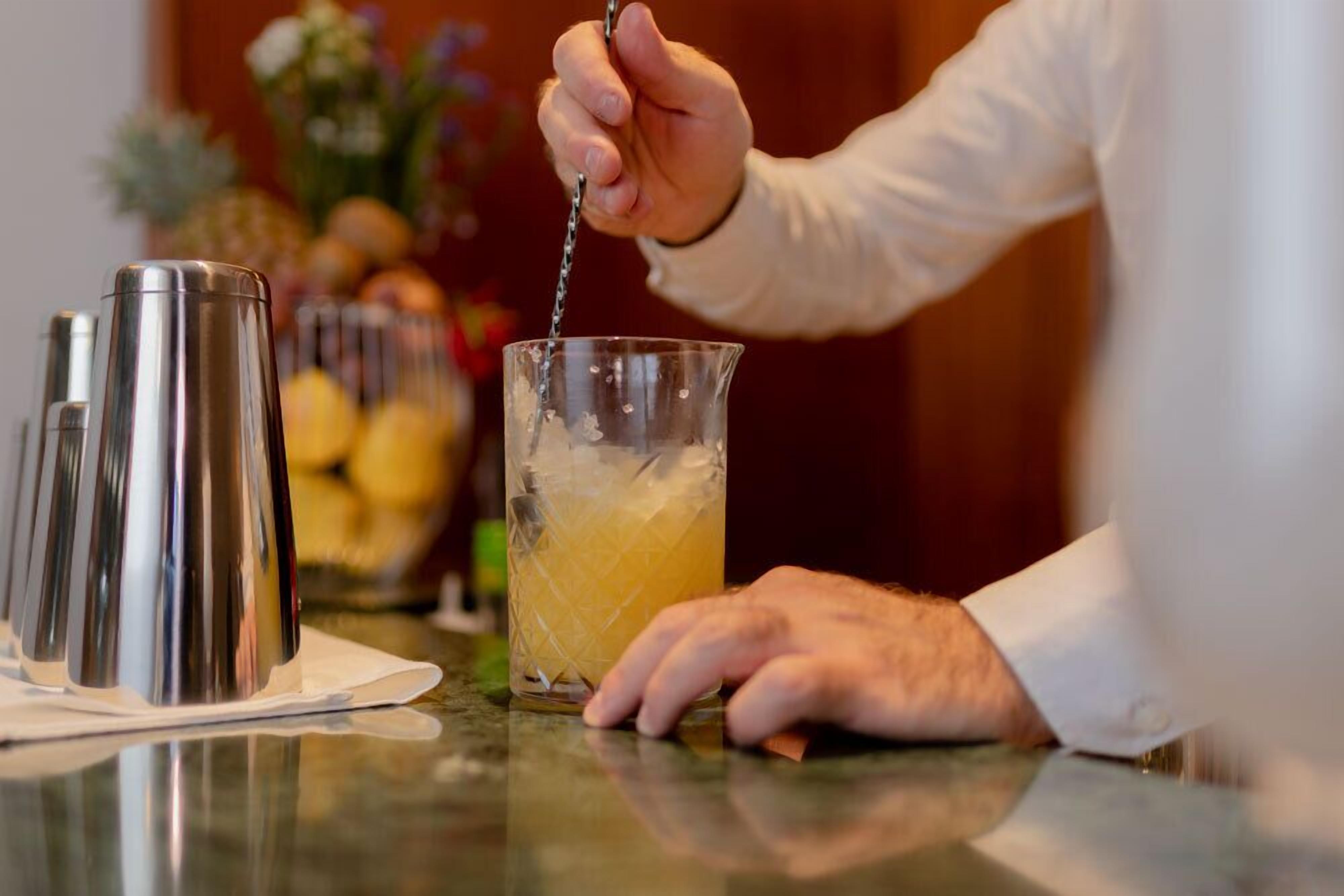 A person pouring a drink into a glass.