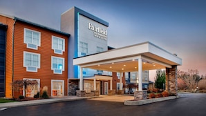Een Fairfield by Marriott hotel met een modern ontwerp, met een overdekte entree en een aangelegde voortuin.