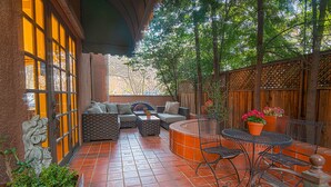 An outdoor patio with a seating area, a round table, and potted plants. - Inn & Spa at Parkside (Sacramento)