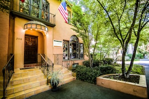A building with a brown door, a sign, and an American flag.