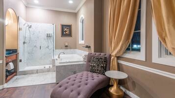 Un baño con ducha de mármol, bañera, tocador con lavabo e inodoro.