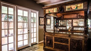 A bar area with a wooden counter, glass display cases, and a large mirror. - Inn & Spa at Parkside (Sacramento)