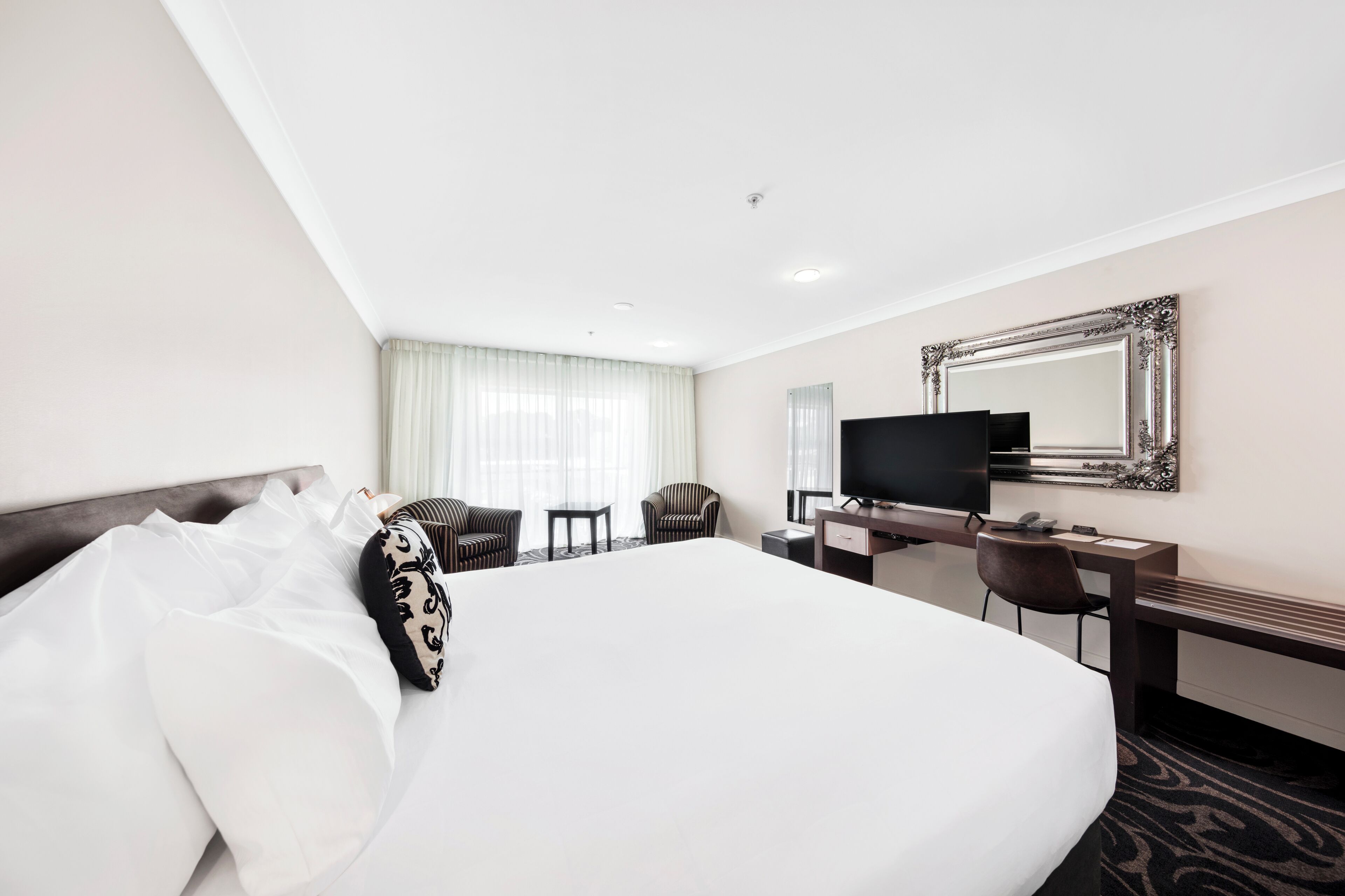 Una scrivania, postazione laptop, tende oscuranti, ferro/asse da stiro