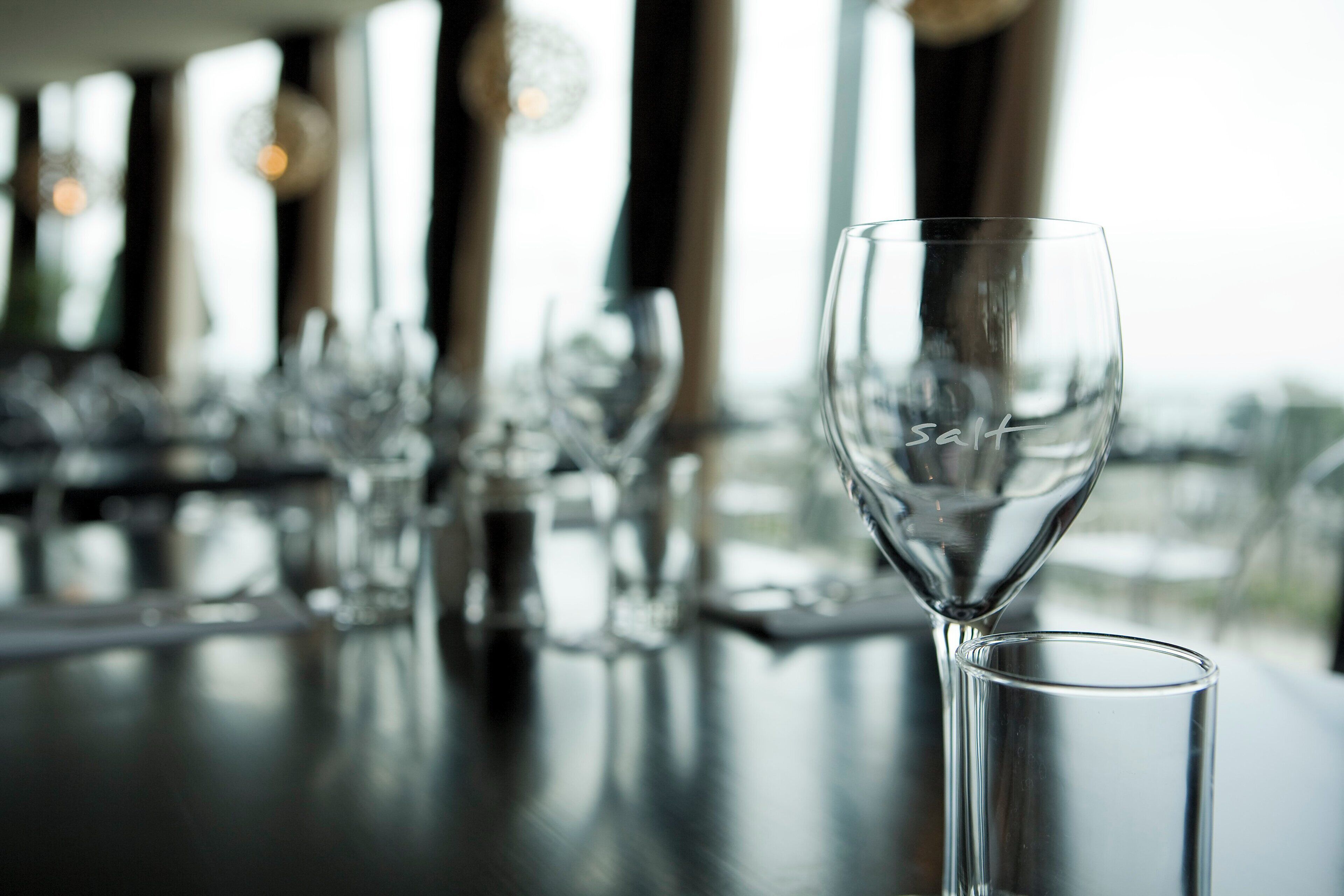 A bar setting with a glass of water and a glass of wine on a table.