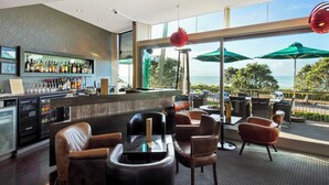 Eine Bar mit Ledersesseln und Meerblick.