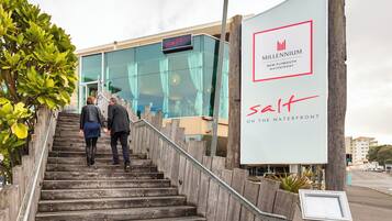 A staircase leading to a modern building with a sign reading "salt" and "Millennium New Plymouth Waterfront."
