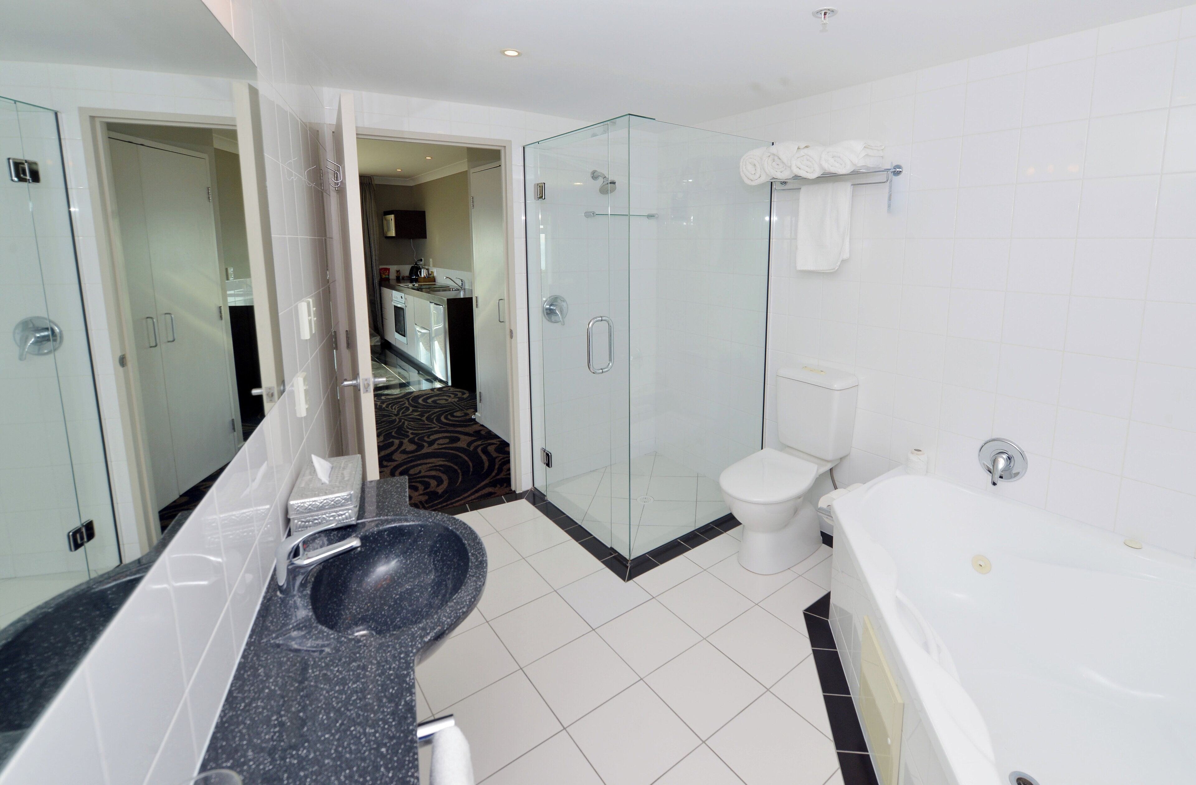 Une salle de bain moderne avec une douche à parois de verre, des toilettes blanches et une baignoire.