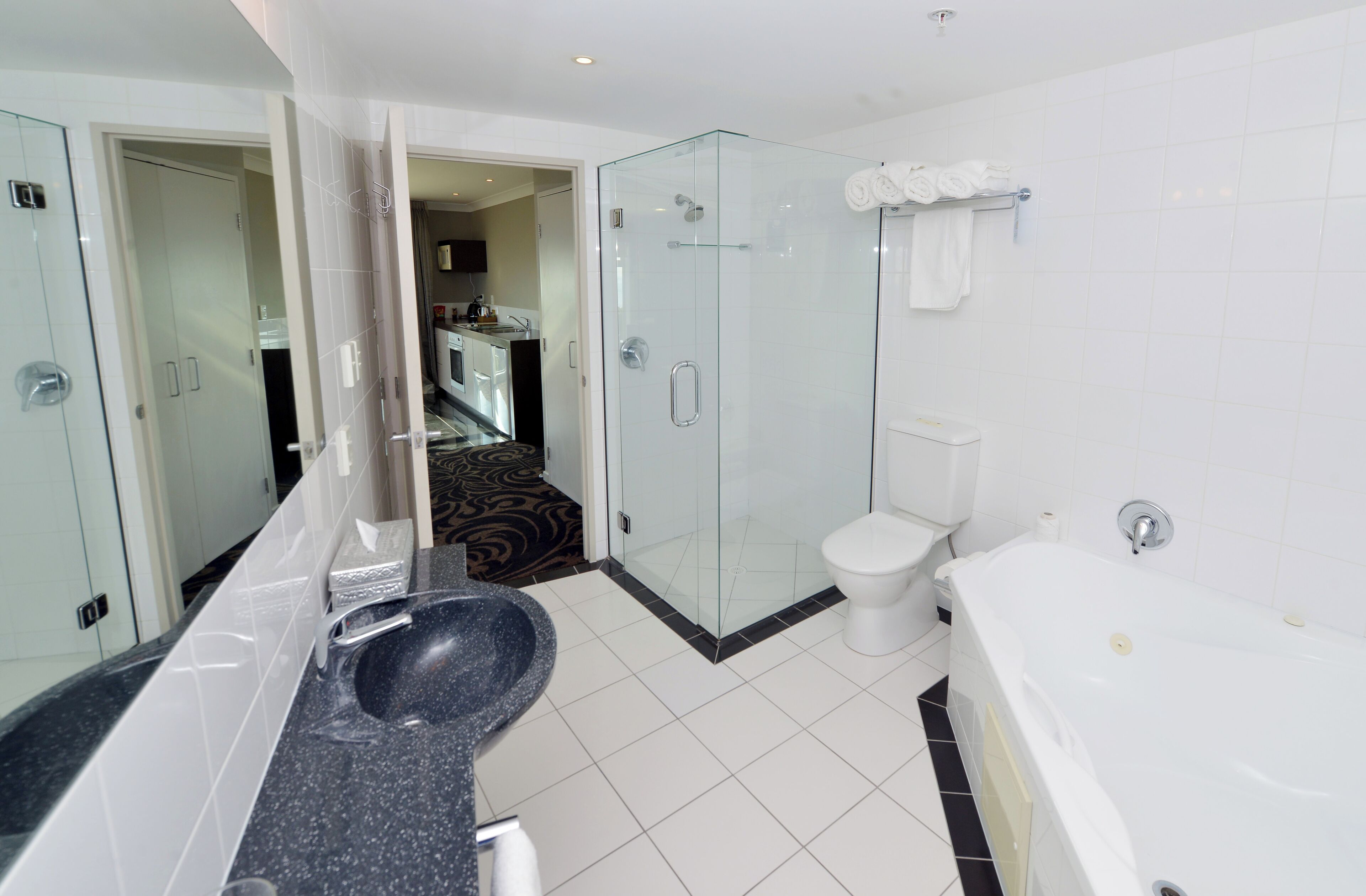 A modern bathroom with a glass-enclosed shower, a white toilet, and a bathtub.