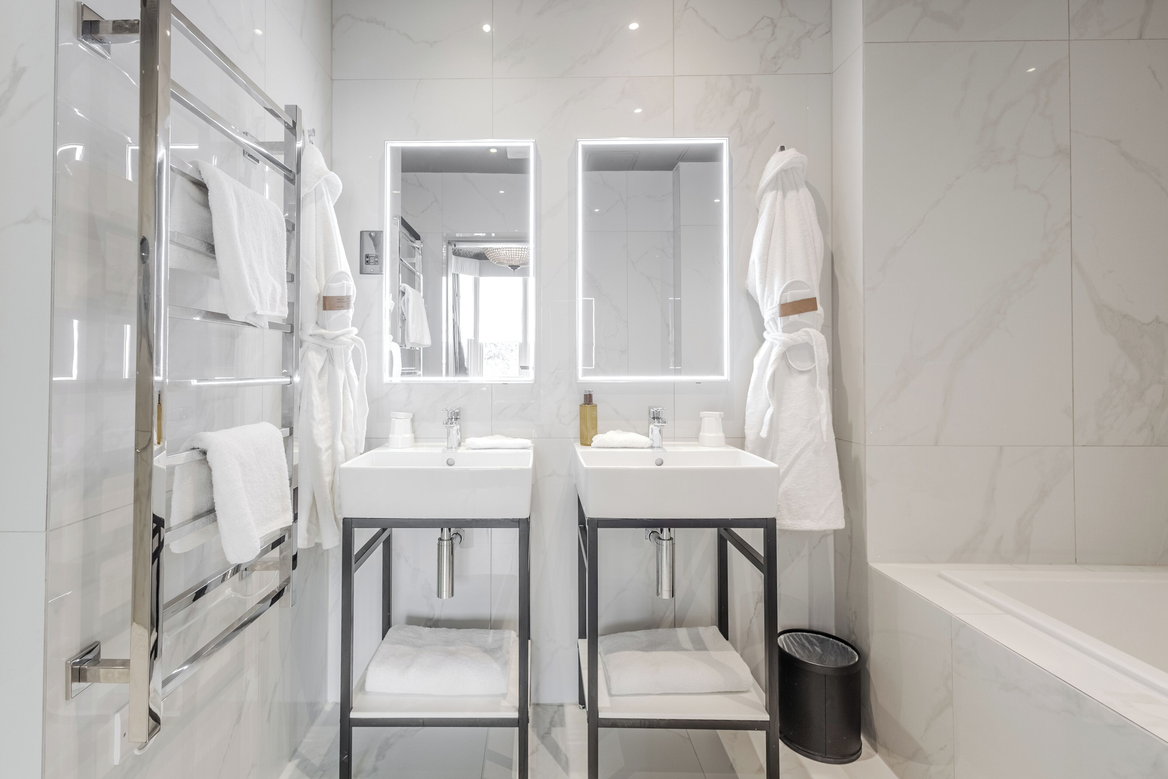 Un bagno moderno con due lavandini, una cabina doccia in vetro e una vasca da bagno.