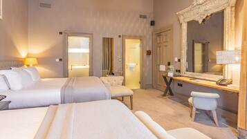 A hotel room with two beds, a desk with a telephone, and a large mirror.
