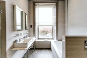 Un baño moderno con dos lavamanos, un espejo grande y una ventana con vistas al exterior.