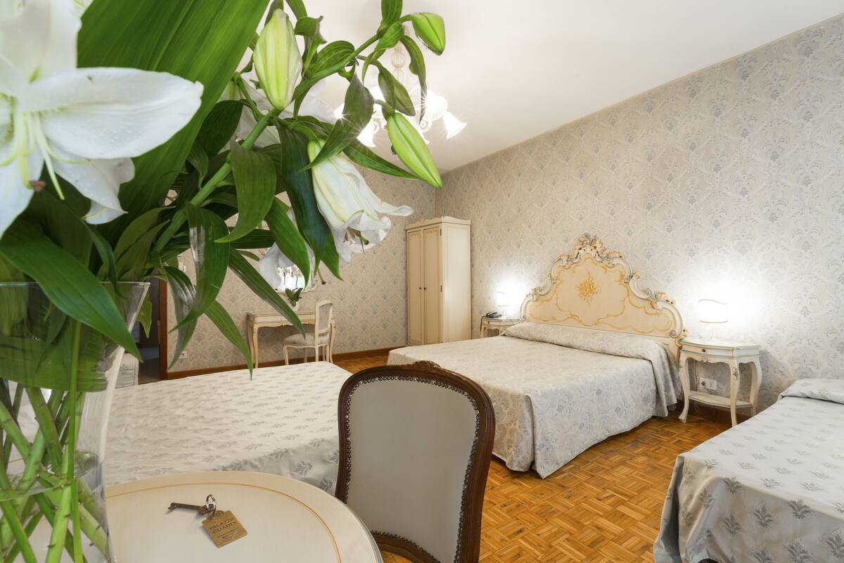 Ett hotellrum med två sängar, ett trägolv, ett skrivbord och en stol.