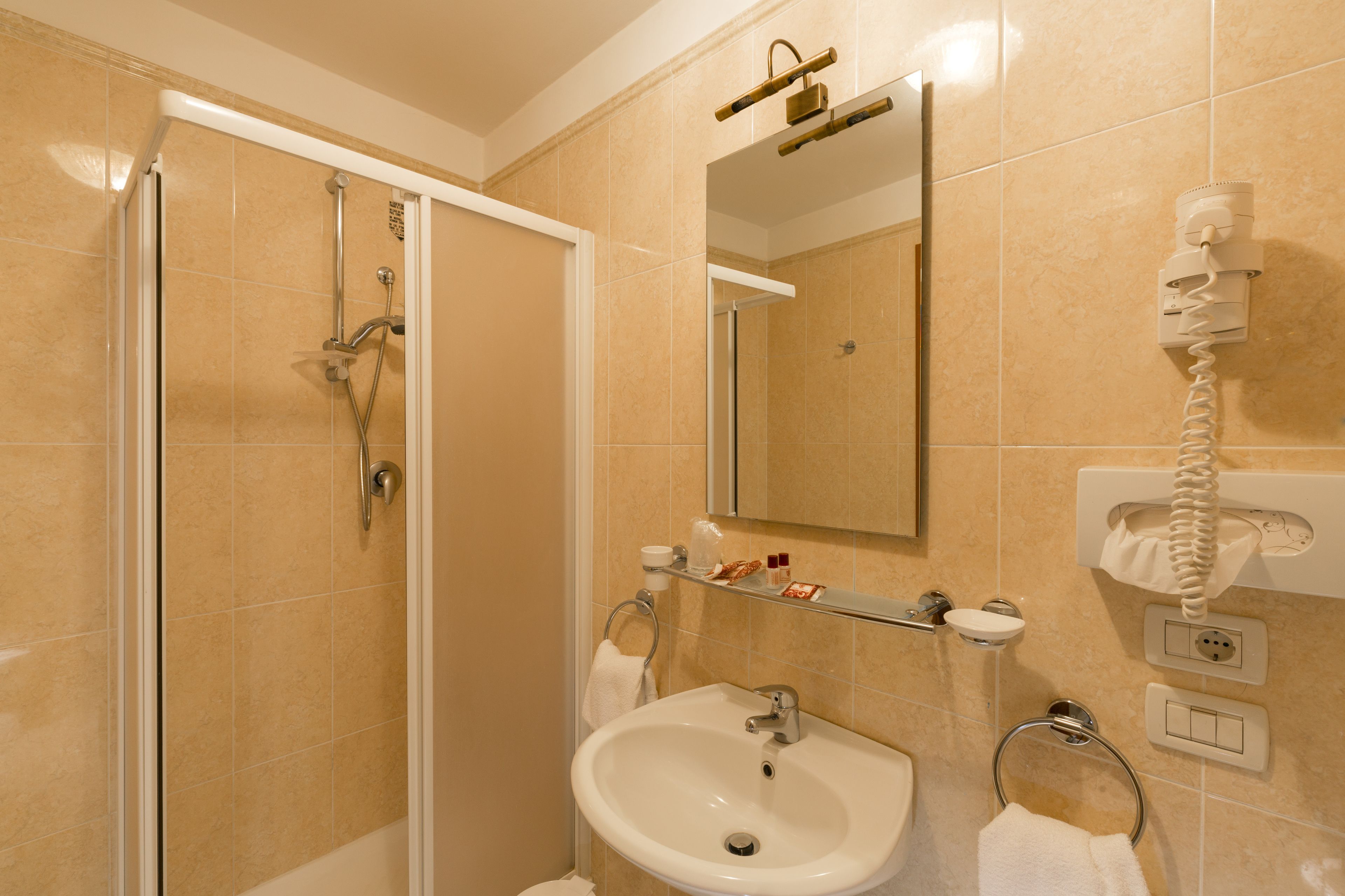 Une salle de bain avec une douche, un lavabo et un miroir.