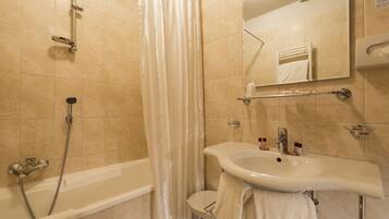 Une salle de bain avec une baignoire, une douche et un lavabo.