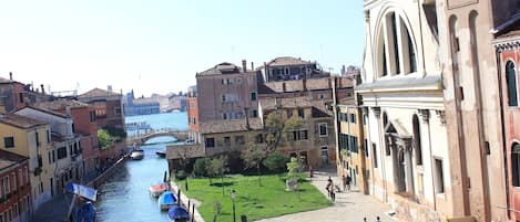 A canal with boats, a bridge, and buildings along the water.