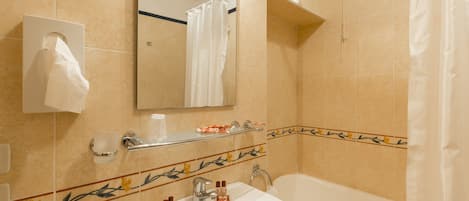 A bathroom with a sink, mirror, and bathtub.