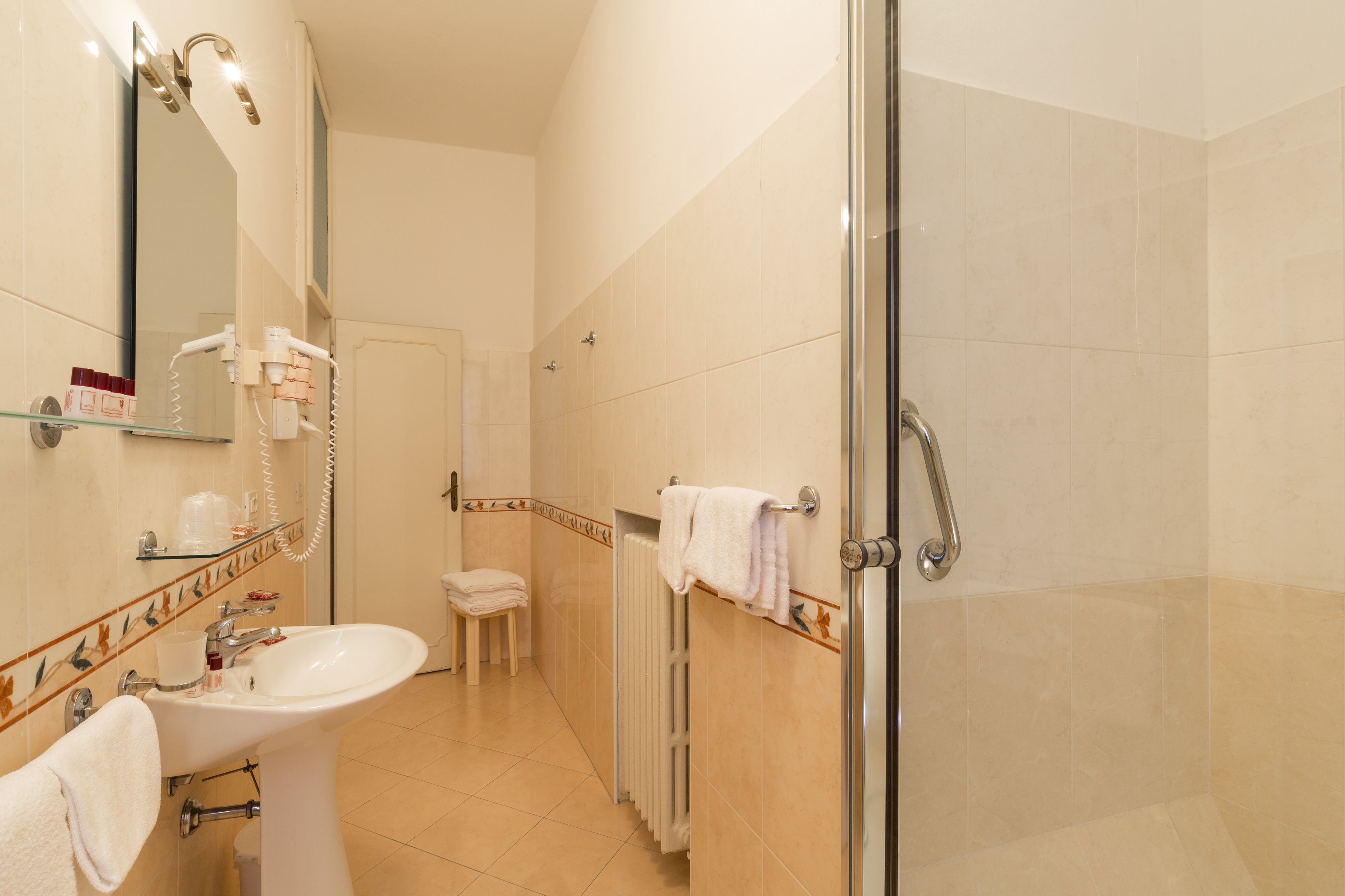 Une salle de bain avec un lavabo, un miroir et une douche.