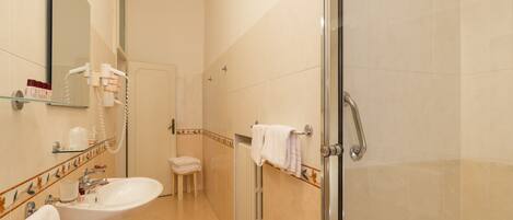 A bathroom with a sink, mirror, and shower.