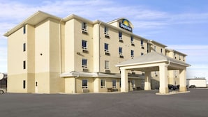 A Days Inn hotel with a beige exterior, a covered entrance, and a parking lot. - Days Inn by Wyndham Moose Jaw (Moose Jaw)