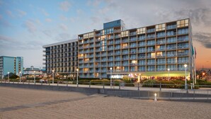 A multi-story hotel with balconies, a beachside location, and a well-lit entrance. - Four Points By Sheraton Virginia Beach Oceanfront (Virginia Beach)