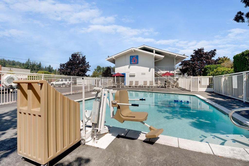 A swimming pool with a lifeguard chair and a changing room.