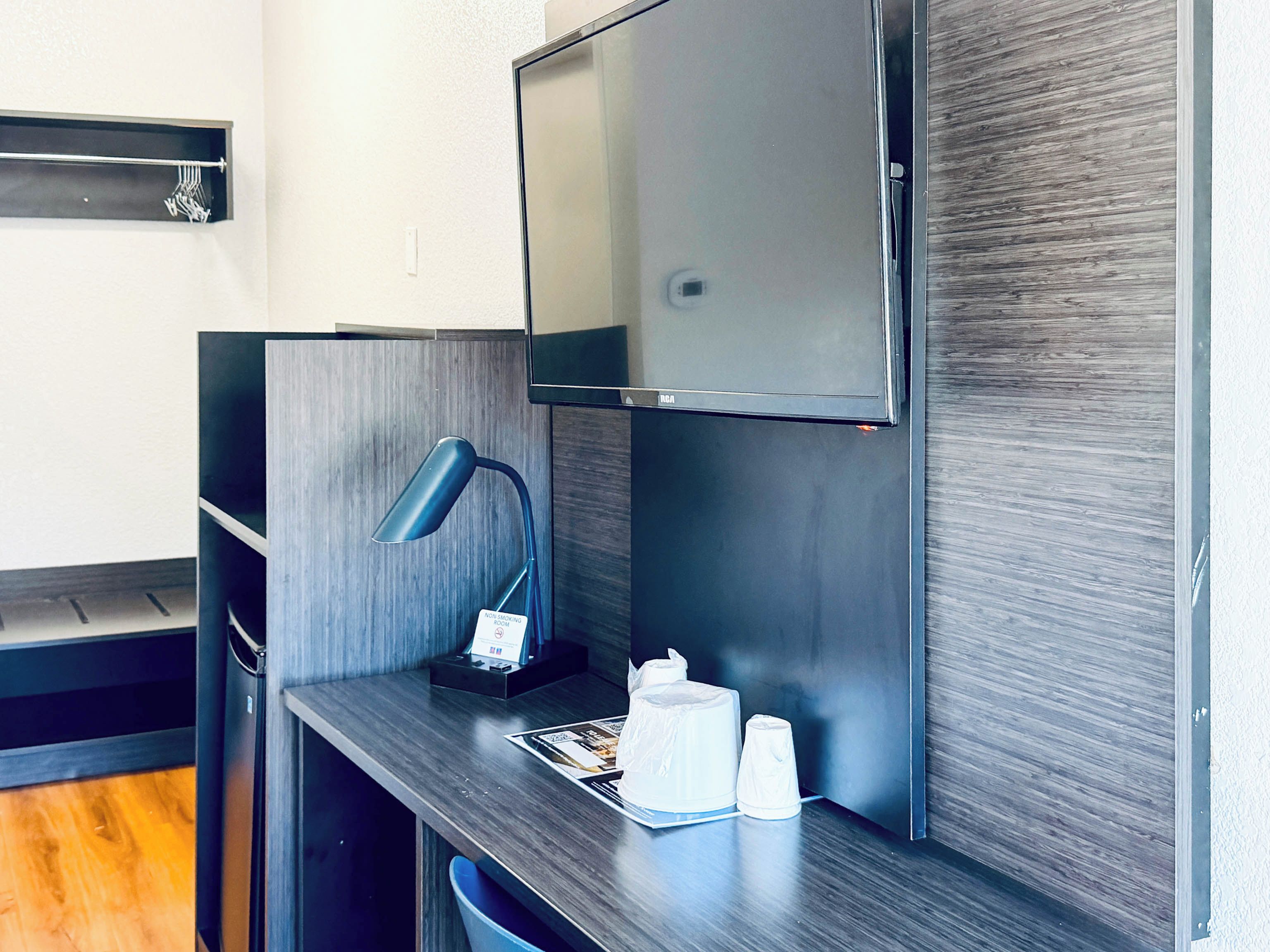 A modern kitchenette with a built-in microwave, a small sink, and a coffee machine.