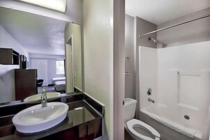 Bañera con ducha, toallas, jabón, papel higiénico