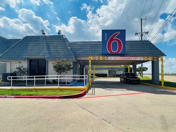 A motel with a blue roof, a '6' sign, and a 'NO PARKING' sign. - Motel 6 Duncanville, TX - Dallas (Duncanville)