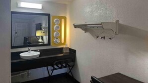 A bathroom with a sink, mirror, towel rack, and a towel dispenser. - Motel 6 Cross Lanes, WV - Goff Mountain Rd (Cross Lanes)