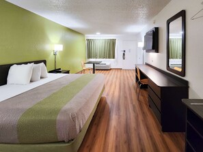 A hotel room with a bed, a desk, a chair, a TV, and a mirror. - Motel 6 Baytown, TX - Baytown East (Baytown)