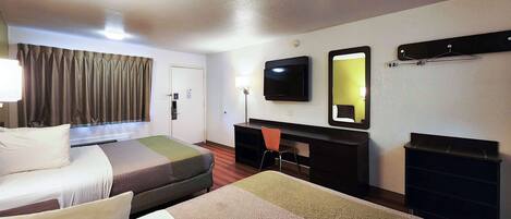 A hotel room with two beds, a desk, a chair, a TV, a mirror, and a coat rack.