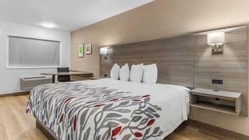 Una camera d'albergo moderna con un letto grande, comodini, una scrivania e uno specchio.