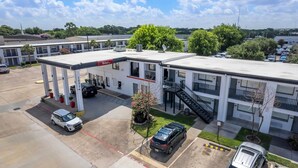 A motel with a gas station, multiple parking spaces, and a small garden area. - Red Roof Inn Houston – Jersey Village (Houston)