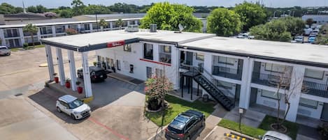 Un motel con una estación de servicio, amplias áreas de estacionamiento y una pequeña zona ajardinada.