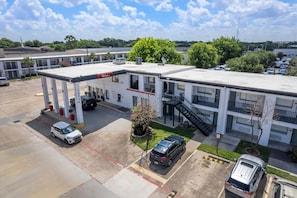 A motel with a gas station, multiple parking spaces, and a small garden area. - Red Roof Inn Houston – Jersey Village (Houston)